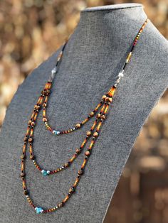 "Authentic Native American, handmade, tiered Cedar Juniper Berry seed with turquoise necklace. Cedar beads, colorful glass seed beads (size 11/0), round silver beads (6mm) and a gemstone bead are strung with jewelry wire and closed with lobster claw clasp. Jumpers are soldered closed. Navajo legend says Cedar beads, also known as \"Ghost Beads,\" will keep evil spirits and bad dreams away. For example, it is customary for Navajo mothers to place strung cedar beads on/near their traditional cradl Brown Heishi Beaded Jewelry, Brown Heishi Beads Jewelry With Tiny Beads, Southwestern Jewelry With Tiny Heishi Beads, Bohemian Brown Heishi Beads Jewelry, Artisan Multi-strand Jewelry With Tiny Beads, Southwestern Multi-strand Jewelry With Colorful Beads, Southwestern Multi-strand Colorful Beads Jewelry, Southwestern Multi-strand Polished Beaded Necklaces, Artisan Multi-strand Jewelry With Spacer Beads