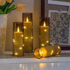 lighted candles and vases on a mantle with tulips