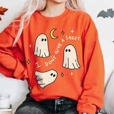 Retro Halloween Ghost Sweatshirt, Funny Boo Ghost Fall Jumper, Cute Ghost Sweater, Trick or Treat Costume, Spooky Season Outfit, UNISEX  Who can resist this aesthetic retro fall themed Halloween Sweatshirt? The illustration on the sweatshirt features 3 ghosts floating around and the funny quote reads 'I don't give a sheet'.  It's comfy and soft make makes a perfect gift for a loved one, or for anyone who is a fan of the grungy vintage autumn aesthetic. This cute sweatshirt is available in multip Spooky Orange Long Sleeve Tops, Orange Long Sleeve Spooky Top, Orange Crew Neck Halloween Sweatshirt, Spooky Long-sleeve Orange T-shirt, Spooky Long Sleeve Orange T-shirt, Spooky Orange Long Sleeve T-shirt, Vintage Autumn Aesthetic, 3 Ghosts, Ghost Sweater