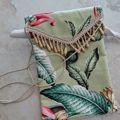 "Love the island styling of this perfect summer vacation small purse. Made of a lovely tropical bark cloth fabric. this envelope style bag is accented with a wooden bead fringe. Purse has a flap over closure featuring a olive green vintage button and a sturdy cotton cord loop. It is fully lined with an ivory cotton fabric has has a poly fleece interfacing for soft quilted body. The cotton cord strap measures 50\" so it is an easy shoulder or cross body carry. This is a great size to carry for ju Beach Shoulder Bag With Adjustable Strap, Green Shoulder Bag For Beach With Mobile Phone Pocket, Green Shoulder Bag With Mobile Phone Holder For Beach, Green Shoulder Bag With Mobile Phone Pocket For Beach, Adjustable Beach Pouch Bag, Green Beach Bag With Mobile Phone Holder, Tropical Beach Shoulder Bag, Tropical Green Shoulder Bag For Travel, Green Tropical Shoulder Bag For Beach