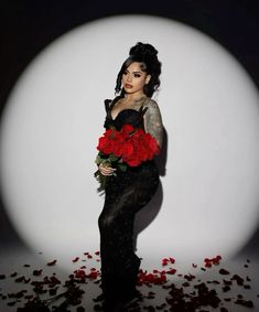 a woman in black dress holding red roses