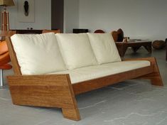 a wooden couch with white cushions in a living room