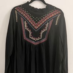 Torrid Crinkle Gauze Embroidered Blouse Nwt Size 1 (1x; 14-16) Deep Black With Embroidery Crinkle Gauze Woven Fabric 100% Rayon High Mock-Turtle Neckline Back Neck Button Closure Blouson Sleeves Never Worn - Nwt Smoke-Free Home Festive Black Embroidered Top With Floral Details, Festive Black Embroidered Floral Top, Festive Black Floral Embroidered Top, Black Long Sleeve Top With Geometric Embroidery, Black Peasant Top With Floral Embroidery, Black Embroidered Long Sleeve Peasant Top, Spring Black Blouse With Geometric Embroidery, Spring Embroidered Black Peasant Top, Casual Black Peasant Top With Floral Embroidery