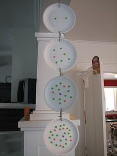 three paper plates hanging from a white pole