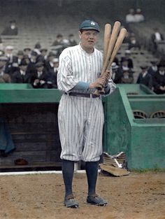 a man holding two baseball bats while standing on a field