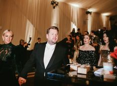 a man in a tuxedo standing next to a woman wearing a black dress