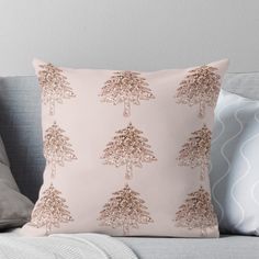 a pink and gold christmas tree pillow on a couch