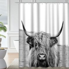 a black and white photo of a long horn cow shower curtain hanging in a bathroom