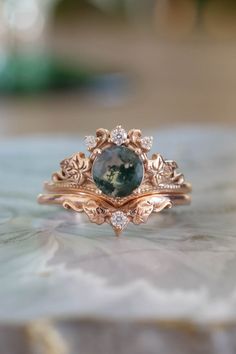 a close up of a ring with a stone in the middle and diamonds around it