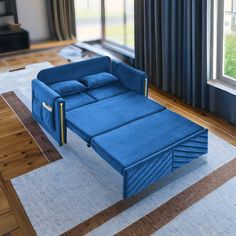 a blue couch sitting on top of a wooden floor next to a window in a living room