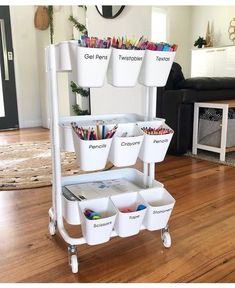 a white cart filled with lots of different colored pencils on top of a hard wood floor