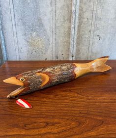 a fish shaped object sitting on top of a wooden table next to a toothbrush