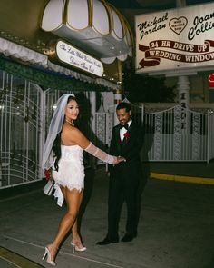 a bride and groom holding hands in front of a sign that reads las harrave up wedding windows