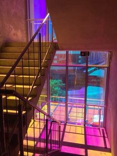 the stairs are lit up with colorful lights in this building's entryway area