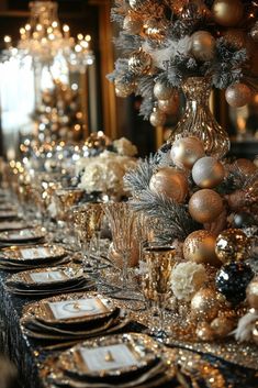 the table is set with silver and gold plates, place settings, and christmas decorations