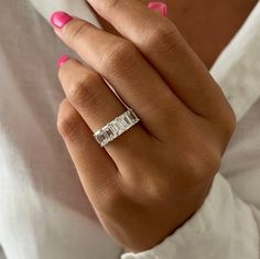 a woman's hand wearing a diamond ring