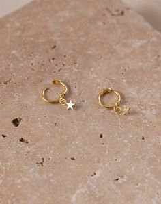 The Gold Star Sleepers are timeless and elegant. This piece in the Celestial collection entails the whimsical wonders of the night sky. Wear with the Starlight Dainty Studs or the Starburst Dainty Studs if you have a second piercing. Size: 18mm, the little star is 3mm Made with 14k gold over S925 silver, tarnish-resistant, hypoallergenic Unfortunately, we are unable to accept returns on earrings due to hygienic reasons. We care about our environment and we hope you do too! Every purchase comes w Dainty Yellow Gold Star Hoop Earrings, Celestial Star-shaped Huggie Earrings With Star Charm, Celestial Star-shaped Gold Huggie Earrings, Gold Star-shaped Celestial Huggie Earrings, Gold Star Celestial Huggie Earrings, Celestial Gold Star Hoop Earrings, Gold Celestial Star Hoop Earrings, Gold Star-shaped Celestial Hoop Earrings, Gold Star Huggie Earrings In Celestial Style