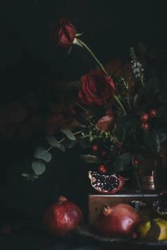 a still life with flowers, fruit and pomegranates on a table