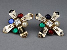 Features: - 100% Authentic MOSCHINO. - Novelty clip earrings representing cross. - Embellished with pearl, red, blue and green glass cabochons. - It used to be gold tone but due to age it became silver, some gold remnants still visible. - Signed MOSCHINO on reverse of one earring. - Good vintage condition. Measurements: Height: 2.28 inches (5.8 cm) Width: 2.28 inches (5.8 cm) Weight per Earring: 16 grams ** These earrings will be shipped via Priority with tracking number. Please convo me for any Multicolor Clip-on Jewelry For Evening, Multicolor Clip-on Evening Jewelry, Elegant Multicolor Clip-on Earrings, Vintage Multicolor Evening Earrings, Vintage Multicolor Earrings For Evening, Multicolor Vintage Evening Earrings, Multicolor Vintage Earrings For Evening, Novelty Earrings, One Earring