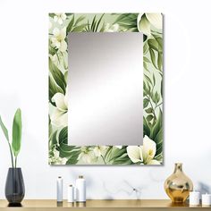 there is a mirror on the wall with flowers and leaves around it in front of a vase