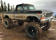 an old pickup truck is parked in the mud