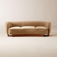 a beige couch sitting on top of a white floor