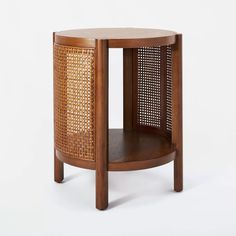 a wooden side table with wicker panels on the top and bottom shelf, against a white background