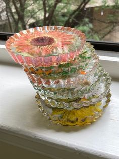 a stack of glass bowls sitting on top of a window sill