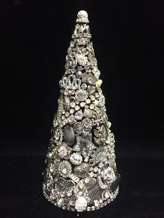 a silver christmas tree with lots of different things on it's sides and the top