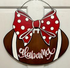 a wooden sign with a red and white bow on it