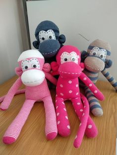 three sock monkeys sitting next to each other on a table