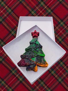 there is a christmas tree made out of cookies in a box on the tablecloth