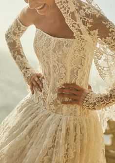 a woman in a white lace dress posing for the camera