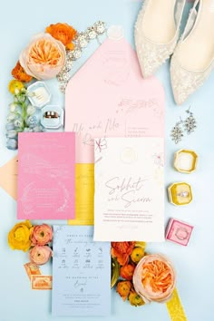 the wedding stationery is laid out on top of each other, including pink and yellow