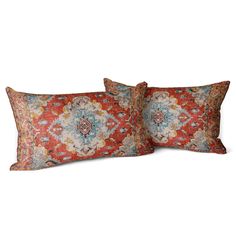 two red and blue decorative pillows on a white background, one with an ornate design