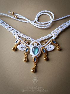 Unique macrame forest necklace with brass drops. Polyester waxed thread: Linhasita frozen white .  Macrame triangle design:  Height: 5,50 cm or 2,16 inches. Width: 7,80 cm or 3,07 inches. Adjustable with a sliding knot. Cabochon Labradorite: light blue flashy with iridescence Length: 1,40 cm or 0,55 inches. Width: 1,10 cm or 0,43 inches. Labradorite round beads. Brass beads: light gold. Brass enamel charms: light gold with blue. Brass charms drops: light gold. Beads: white. All brass elements: n White Macrame Necklace For Festival, White Macrame Necklace For Festivals, Handmade White Crystal Dangle Necklace, White Jewelry With Adjustable Cord For Festivals, Bohemian White Jewelry For Festivals, Festival Macrame Pendant Necklace, Bohemian White Dangle Necklaces, Handmade White Bohemian Necklaces, Handmade White Crystal Choker Necklace