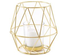 a glass candle holder with a gold geometric design and a white candle in the center