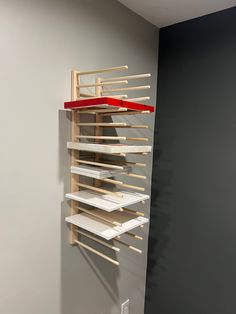 a wall mounted shelf with several shelves on each side and a red shelf above it