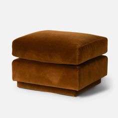 a brown ottoman sitting on top of a white floor