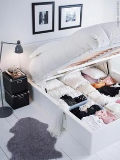 an open suitcase sitting on top of a bed in a room with white walls and flooring