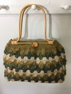 "1950s NOS w/o Tags Raffia Crochet Handbag, 50s Purse, Mid Century Accessory Amazing 1950s multi colored crocheted raffia handbag in greens and beige. This vintage handbag features two wooden bamboo handles and has a button and loop closure. Opens to a large open area with a structured bottom. Mint condition *new old stock without tags. Measurements: Width x 12\" Depth x 4\" Height w/o handle x 10\" Height w/handle x 18\"" Vintage Handmade Straw Bag For Everyday, Vintage Handmade Straw Bag For Daily Use, Vintage Handmade Everyday Straw Bag, Handmade Vintage Straw Bag For Daily Use, Vintage Crochet Bag In Natural Color For Daily Use, Vintage Natural Crochet Bag For Daily Use, Vintage Straw Bag For Everyday Use, Vintage Straw Bag For Daily Use, Vintage Natural Straw Bag For Daily Use