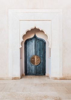 an ornate doorway with a blue door in the middle