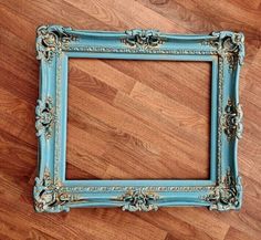 an old blue frame is sitting on the floor with a wooden floor in front of it