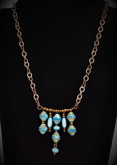 This necklace features beautiful Sky/Azure Blue etched picasso Czech glass beads with wonderful colors and detail.  Check out the 2nd picture which provides the best shot of the true colors on this handcrafted piece.  Bronze, light blue Cat's Eye beads, and baby blue czech rondelles are added and spaced across a bronze bar. The pendant is strung on medium sized cable style bronze chain.  The back features a hand made hammered hook which allows for length adjustability with the chain.  Back dangle finished this one-of-a-kind creation. Light Blue Single Strand Jewelry For Jewelry Making, Artisan Blue Necklace With Large Beads, Blue Artisan Necklace With Large Beads, Adjustable Turquoise Necklace As A Gift, Adjustable Dangle Glass Necklace, Adjustable Turquoise Necklace For Gift, Adjustable Light Blue Turquoise Necklace Gift, Adjustable Czech Glass Beaded Chain Necklace, Blue Glass Necklaces With Adjustable Chain