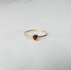 This Garnet Heart Ring brings love with you wherever you go. Show someone you love that you always have them in your heart. A great gift ring! Details: 14k gold (available in yellow, rose or white gold)Garnet heart measures about 3mm Free Shipping on Domestic Orders Materials: Garnet, 14k gold Need your ring bigger than whats offered? An additional fee will be applied to ring orders larger than size 8. Please contact us for exact pricing or feel free to place your order and we will send you an a Garnet Heart Ring, Jewel Rings, Garnet Heart, Heart Rings, Gold Heart Ring, Dope Jewelry, Garnet Jewelry, Garnet Ring, Jewelry Lookbook