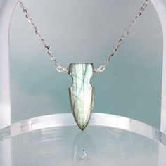 This one-of-a-kind arrow Labradorite necklace boasts a stunning arrow-shaped pendant on a sturdy 925 sterling silver chain. The wire used is also made of high-quality 925 sterling silver. The arrow-shaped Labradorite stone showcases a mesmerizing green hue with a dazzling blue flash when hit by sunlight. Make a statement by adding this handcrafted Labradorite necklace to your fine jewelry collection or give it as a gift to a special someone. Materials: Labradorite, 925 sterling silverPendant dim Handmade Sterling Silver Arrowhead Necklace, Labradorite Necklace, Labradorite Necklaces, Stone Pendant Necklace, The Wire, 925 Sterling Silver Chain, Labradorite Stone, Labradorite Pendant, Fine Jewelry Collection