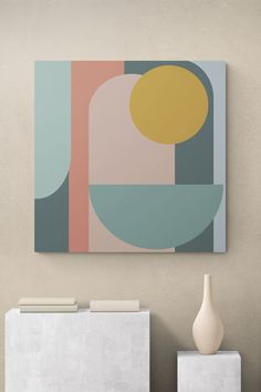 an abstract painting hangs on the wall next to two white cubes and a vase