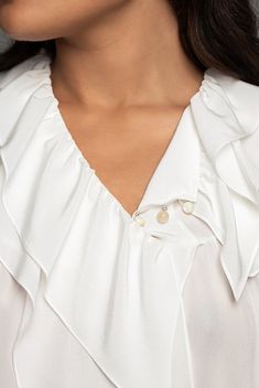 This chic blouse has ruffled details around the neck. Its mother-of-pearl buttons at the front and its long delicate sleeves with smocked cuffs at the wrist accentuate a balance between delicateness and femininity, to enhance its chic effortless attitude. The model is 176 cm and wears a prototype in size 36.Made in FranceColour: off-white Main material and lining: 100% SE, concealed mother-of-pearl buttons at the front.Care: dry cleaning onlySustainability fabric: Greenpeace Detox protocol & PFC Crepe Blouse, France Colors, Family Brand, Chic Blouses, White Silk, Mother Of Pearl Buttons, Pearl Buttons, Silk Crepe, Free Fabric