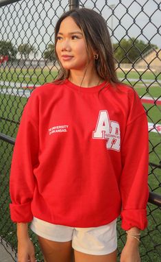 This red crewneck sweatshirt has a vintage feel with the "AR" on the chest. The tiny print is simultaneously trendy and timeless. Haley is 5'6" and is wearing size XL Phoebe is 5'4" and is wearing size medium sizing guide: small: 40” bust | 26” length medium: 46” bust | 27” length large: 48” bust | 28” length extra large: 50” bust | 29.5” length extra extra large: 56” bust | 31” length 50% cotton | 50% polyester WE ONLY OFFER STORE CREDIT FOR RETURNS! Feel free to email us at orders@shopriffraff University Red Varsity Crew Neck Sweatshirt, University Red Varsity Sweatshirt With Crew Neck, University Red Crew Neck Sweatshirt For Game Day, Red Long Sleeve Sweatshirt For Campus, University Red Crew Neck Sweatshirt For Fall, Collegiate University Red Crew Neck Sweatshirt, University Red Collegiate Crew Neck Sweatshirt, Hamptons Summer, Western Tee