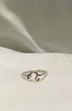 a silver ring sitting on top of a white cloth